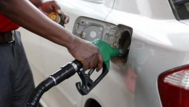 A petrol station attendant pumping fuel into a car.