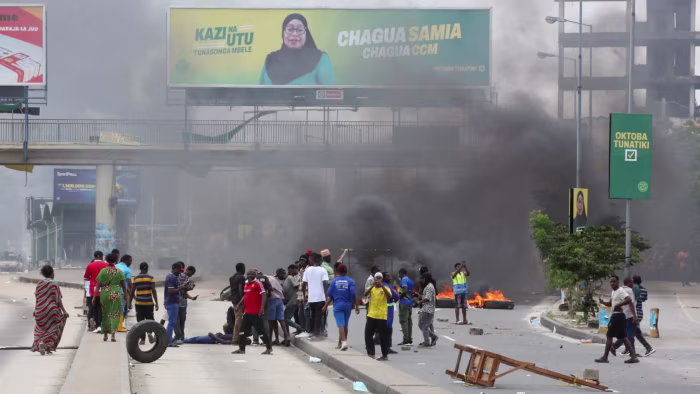 Demonstrators in Dar es Salaam attend to a man shot during violent protests that marred the election © Onsase Ochando/REUTERS